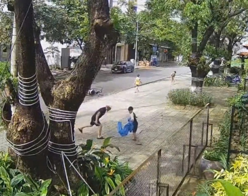 Người đàn ông dùng một vật (giống đoạn cây) đánh liên tục vào chân các cháu. Ảnh: PLO.