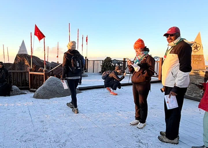 Du khách thích thú với băng giá trên đỉnh Fansipan, sáng 25/12. (Ảnh: VnExpress)