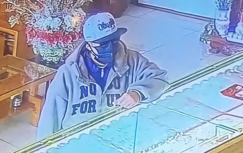 Nam thanh niên mang khẩu trang che kín mặt khi tiếp cận, cướp tiệm vàng. (Ảnh: Dân trí).