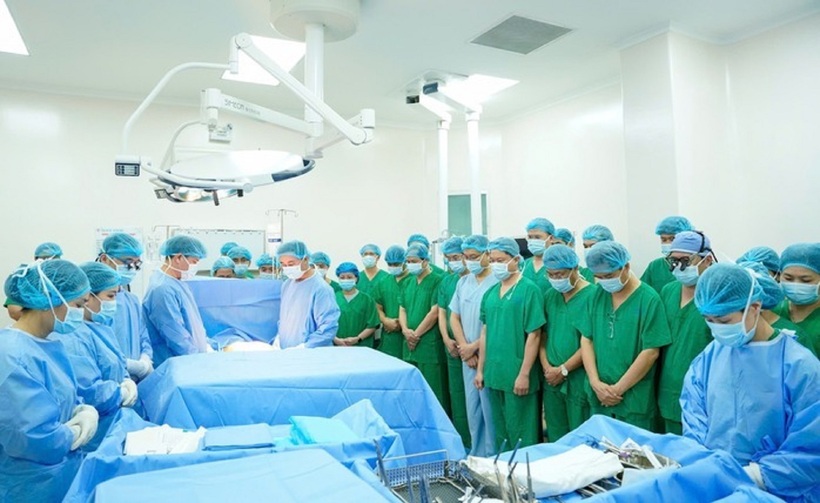 Các y bác sĩ dành phút mặc niệm trước nghĩa cử đầy nhân văn của người hiến tạng. Ảnh: Người Lao Động.