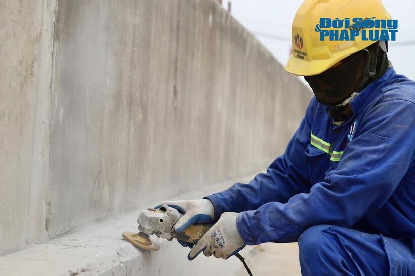 Công nhân đang mài hoàn thiện bề mặt bê tông bên trong và bên ngoài hầm