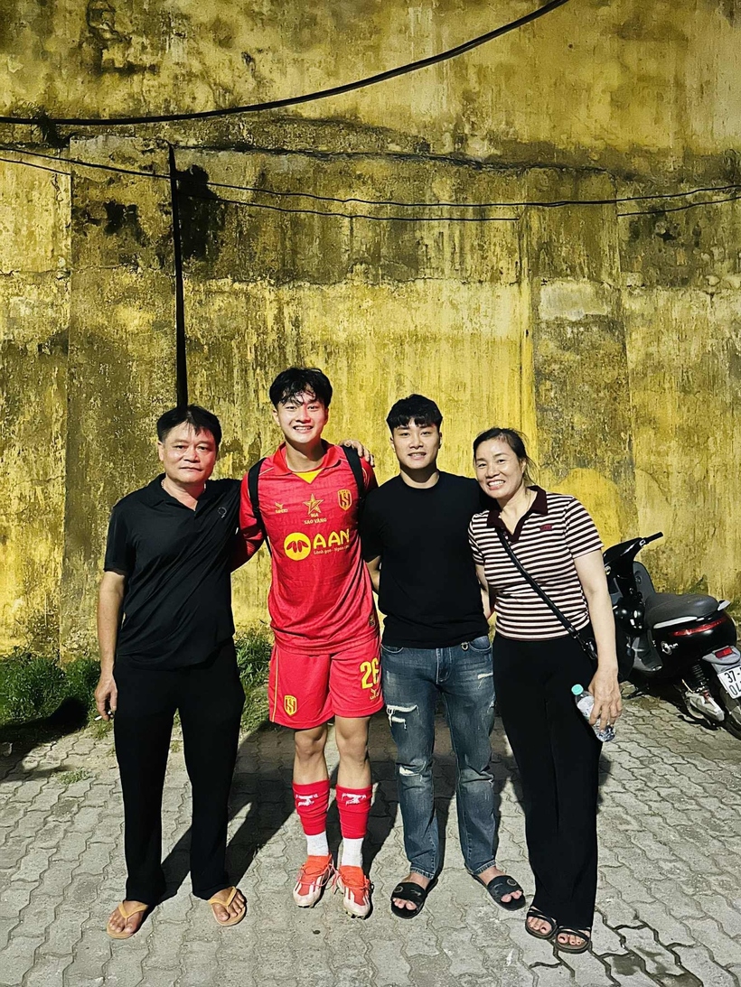 Thủ môn Văn Bình (áo đỏ) chụp ảnh cùng bố mẹ và anh trai.