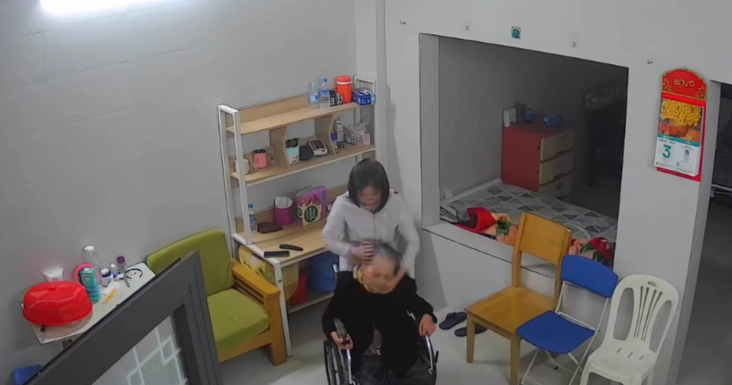 Hình ảnh nữ giúp việc bạo hành cụ bà ngồi trên xe lăn. (Ảnh cắt clip)
