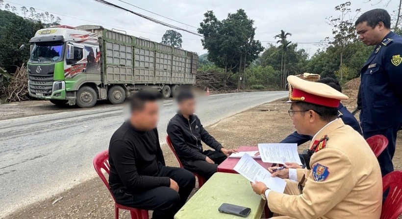 Lực lượng chức năng lập biên bản với hai lái xe, tạm giữ phương tiện và hàng hóa. (Ảnh: Tiền phong)