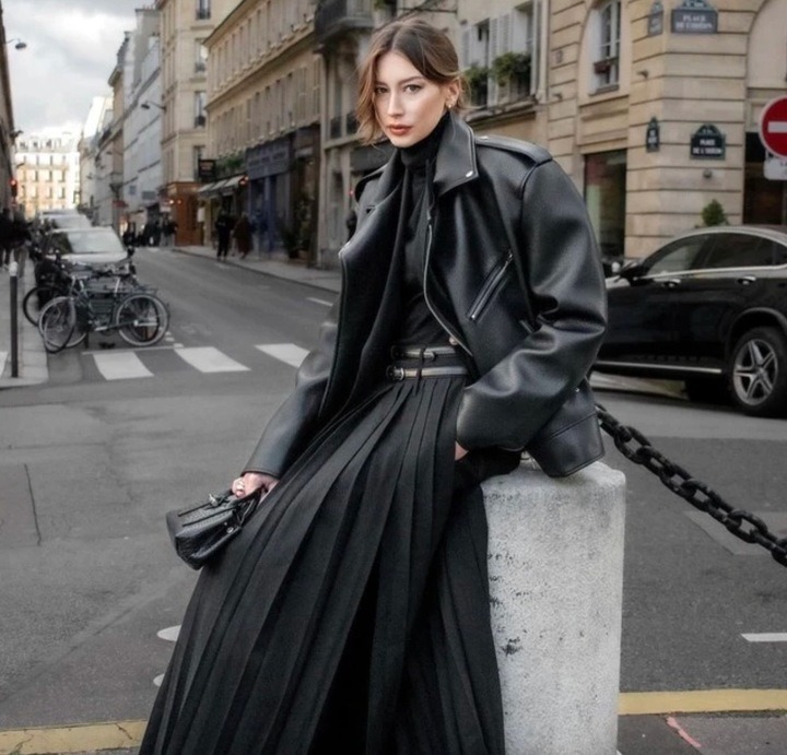 Thay vì kết hợp với quần jeans hay quần âu thanh lịch, bạn cũng có thể phối áo khoác da với chân váy xếp ly dáng dài.