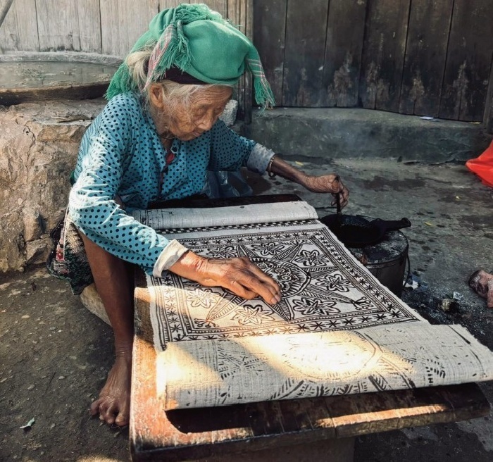 Phụ nữ dân tộc H’Mông tỉ mỉ vẽ sáp ong lên vải lanh.
