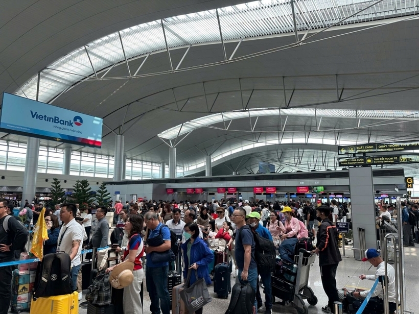 Người dân xếp hàng làm thủ tục tại nhà ga T1 của sân bay Tân Sơn Nhất khá đông trong ngày 13/2.
