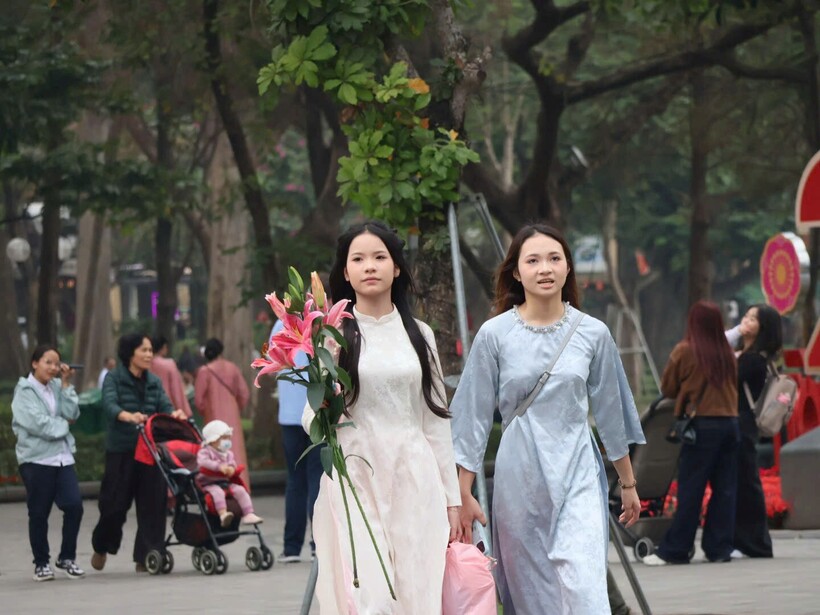 Nhiều bạn trẻ, gia đình đã diện áo dài truyền thống, tay cầm bó hoa để check-in.