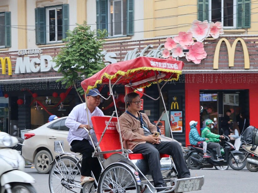 Du khách thích thú trải nghiệm xích lô dạo quanh hồ Hoàn Kiếm, tận hưởng không khí rộn ràng những ngày cận Tết.
