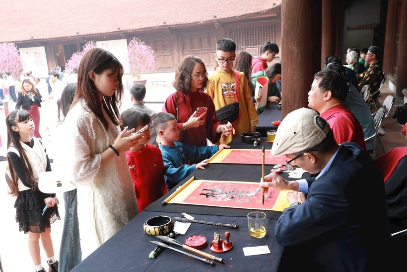 Hoạt động xin chữ trở thành dịp để các gia đình sum vầy, gìn giữ truyền thống. Ảnh: Hà Nội Mới