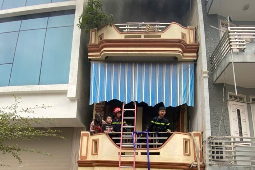 Lực lượng cứu nạn đưa hai mẹ con thoát khỏi căn nhà có cháy trong sáng mùng 1 Tết. (Ảnh: VnExpress)