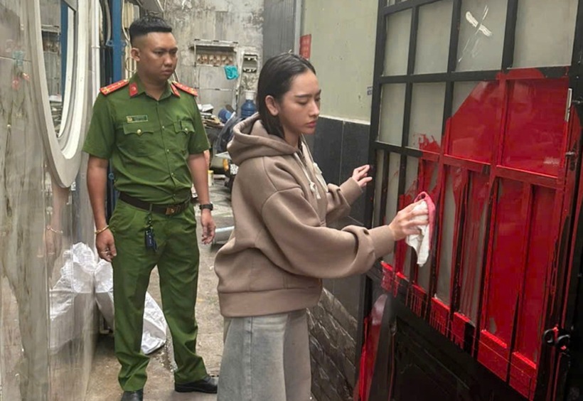 Phạm Ngọc Mỹ Tiên bị cảnh sát yêu cầu lau các vết sơn. (Ảnh: Công an TP.HCM)