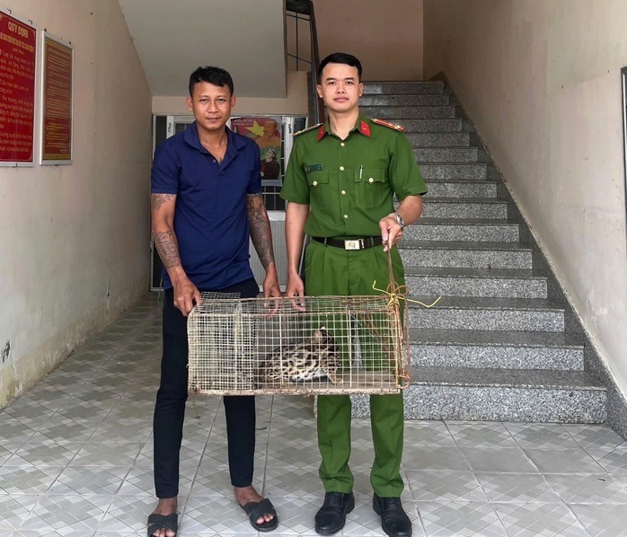 Anh Cường bàn giao con mèo rừng cho công an. (Ảnh: Người lao động)