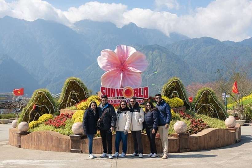 Du khách nước ngoài check-in bên biểu tượng hoa đào tại Fansipan.