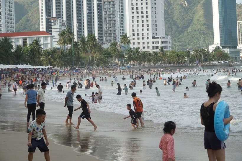 Người dân, du khách đến bãi biển Nha Trang vui chơi, tắm biển trong dịp Tết. (Ảnh: Tiền phong)