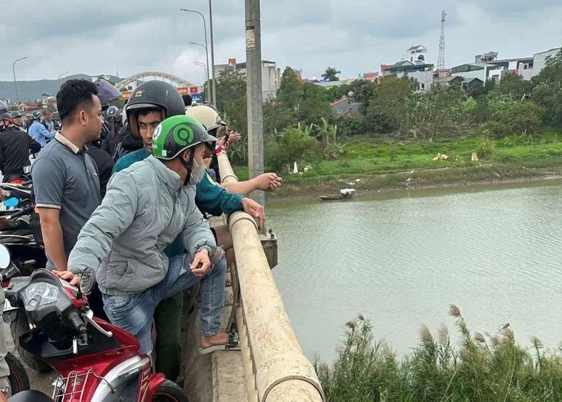 Người dân hiếu kỳ đứng lại cầu Lèn xem việc đưa thi thể anh S. lên bờ. (Ảnh: Công lý)