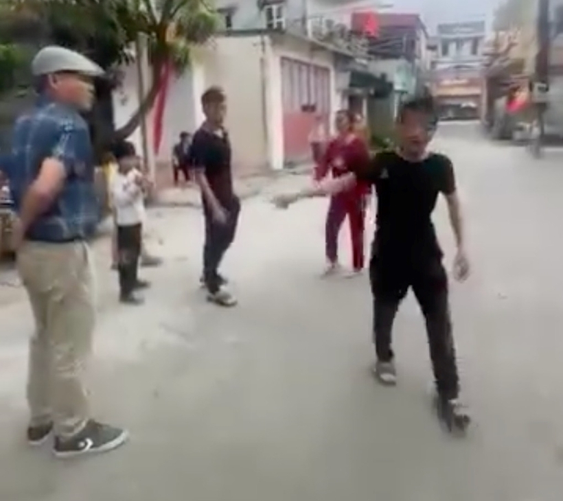 Hai người dân ra đòi tiền đỗ xe trước cổng chùa Gôi. Ảnh: Dân trí