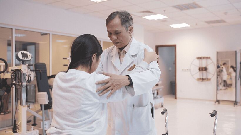 M. chập chững tập đi dưới sự hướng dẫn của bác sĩ phục hồi chức năng.