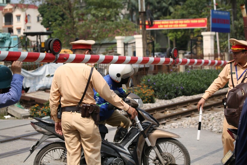 CSGT và nhân viên gác chắn “giải cứu” shiper mắc kẹt khi cố vượt rào chắn đường ngang.