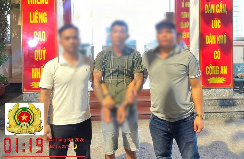 Lực lượng Công an bắt giữ đối tượng truy nã về tội Cố ý gây thương tích (đứng giữa). Ảnh: Lao động