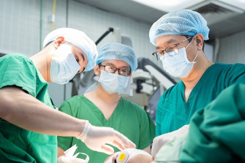 Ê kíp bác sĩ phẫu thuật bắc cầu động mạch não cho nữ bệnh nhân. Ảnh: Báo Công lý.