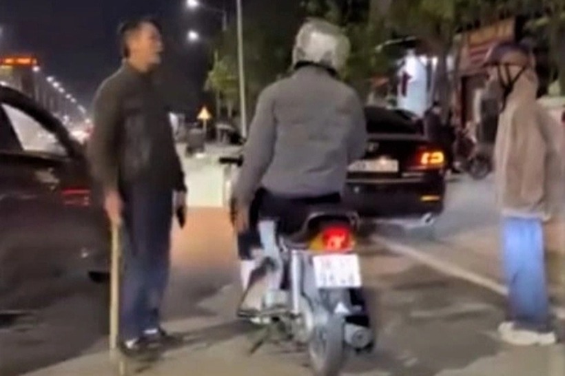 Tài xế dừng ô tô giữa đường và cầm gậy đe dọa người đi xe máy. Ảnh: Dân trí