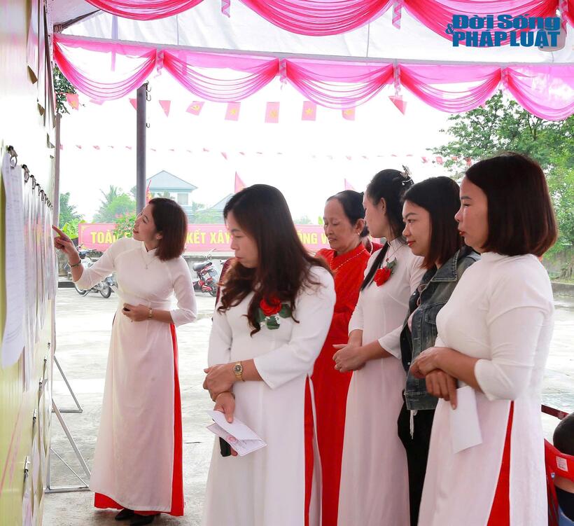Chị Nguyễn Thanh Huyền, xã Hồng Vũ, Hưng Yên (áo dài cài hoa, tay cầm lá phiếu chính giữa) vinh dự khi được thực hiện quyền công dân