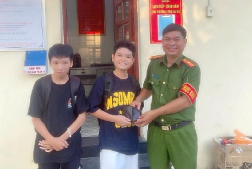 Em Trần Gia Bảo và Lê Duy An, học sinh lớp 8/4 Trường THCS Long Thành đến Công an xã Long Thành nhờ tìm người đánh rơi ví. (Ảnh: Tiền phong)