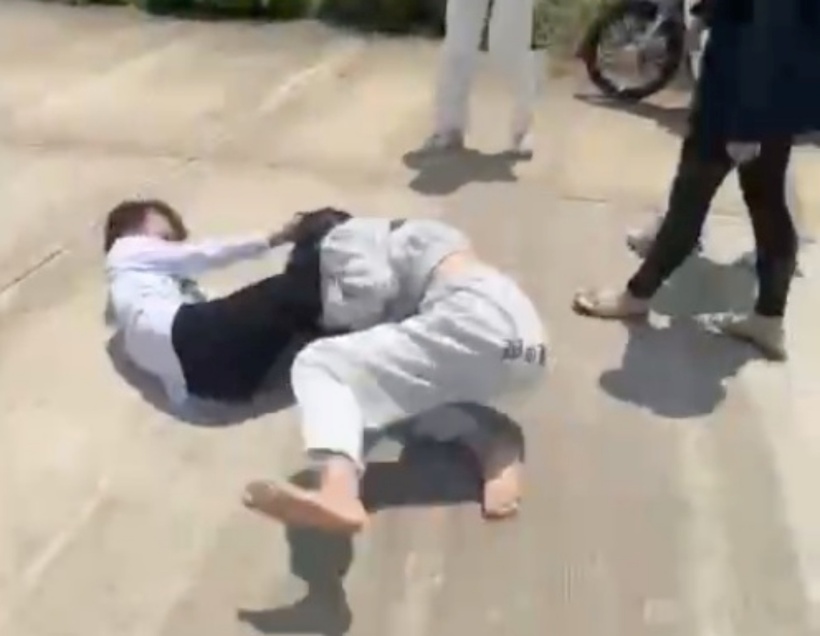 2 nữ sinh "thách đấu", sau đó lao vào túm tóc, đánh nhau, giằng co khá lâu, rồi vật nhau ngã xuống nền bê tông. Ảnh: Báo Thanh niên.