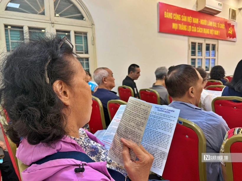 Người dân chăm chú theo dõi tờ rơi do Hội Luật gia Tp.Hà Nội phát tại Hội nghị.