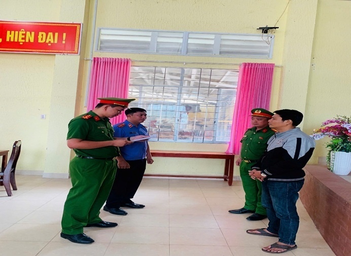 Lực lượng chức năng tống đạt quyết định khởi tố bị can và thi hành lệnh bắt tạm giam bị can. Ảnh: Người đưa tin