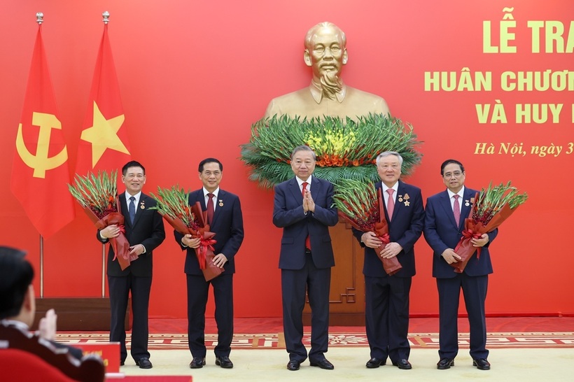 Tổng Bí thư Tô Lâm tặng hoa chúc mừng các đồng chí được nhận Huy hiệu Đảng (Ảnh: VGP).