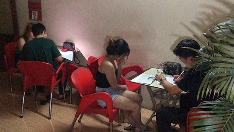 Cơ quan công an làm việc với gái bán dâm tại một quán cà phê. Ảnh: Người lao động