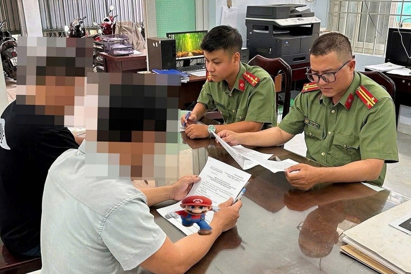 Lực lượng công an làm việc với 2 người đàn ông đăng tải thông tin sai sự thật trên Facebook. Ảnh: Dân trí