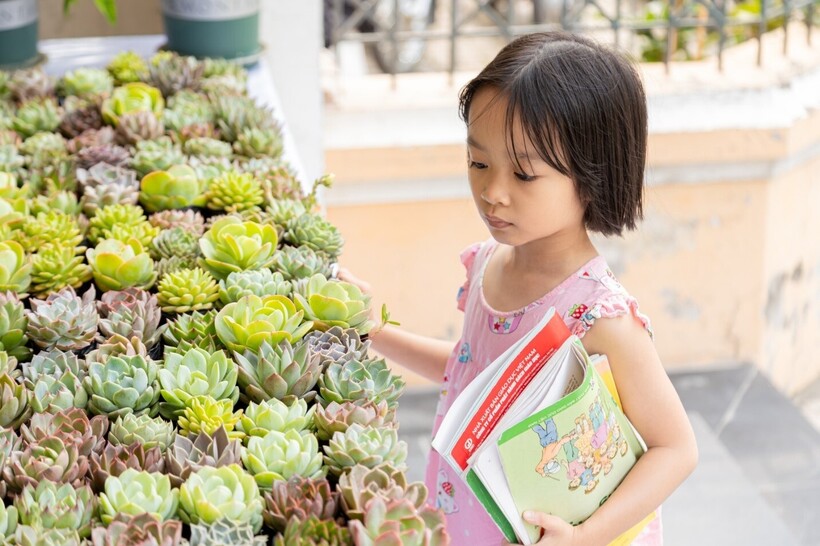 Một em nhỏ mang sách cũ đến điểm đổi quà sen đá tại KTX Đại học Quốc gia Hà Nội – cơ sở Mễ Trì.