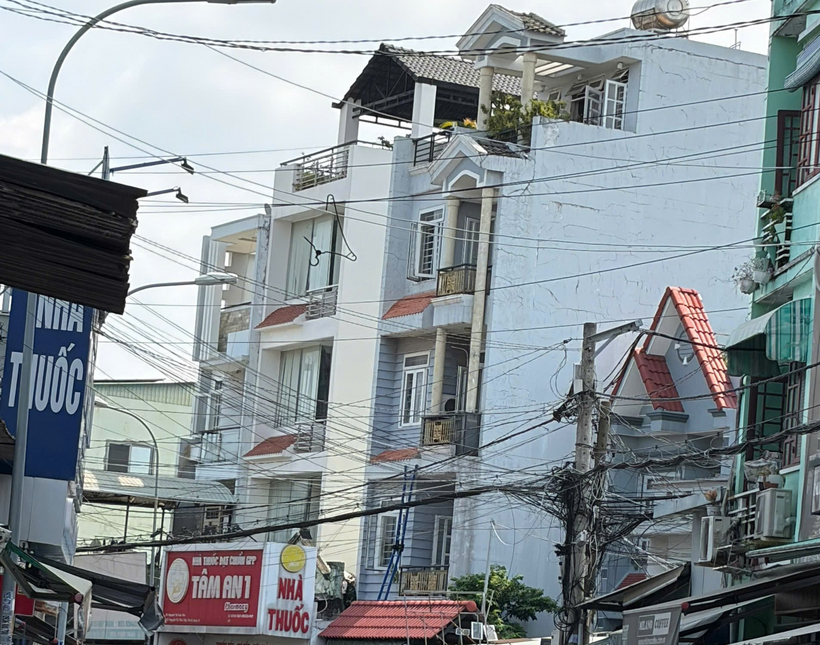 Phía bên ngoài căn nhà trọ xảy ra hỏa hoạn, thang cứu hộ vẫn còn treo lơ lửng. Ảnh: VietNamnet