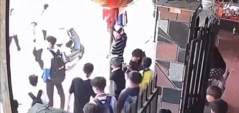 Khi vừa tan học, em T đứng trước cổng trường thì có hai thanh niên đeo khẩu trang tiếp cận. Ảnh: Báo Công an Nhân dân.