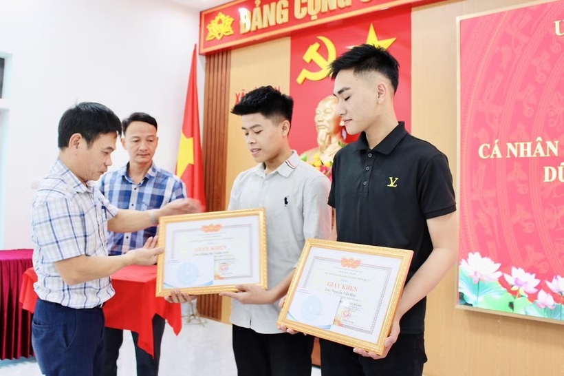 Lãnh đạo xã Tân An trao tặng Giấy khen cho hai nam sinh dũng cảm cứu người. Ảnh: Tiền Phong