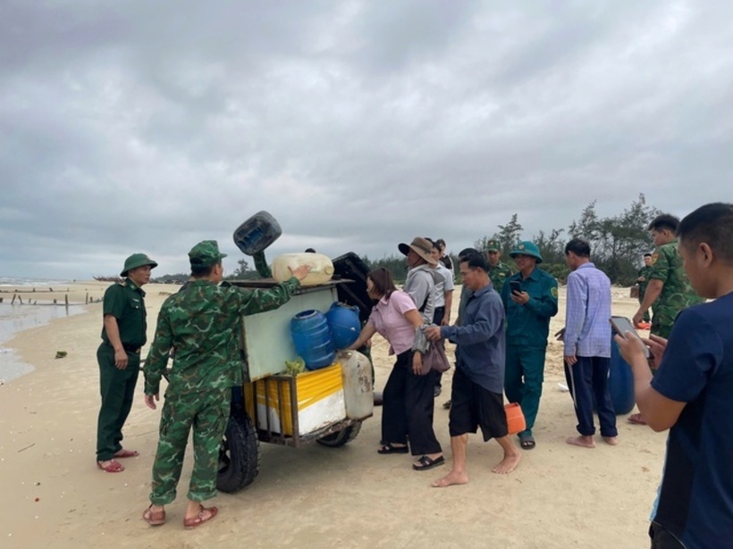 Lực lượng chức năng và người dân hỗ trợ thu gom tải sản trên tàu bị trôi dạt. (Ảnh: Đồn Biên phòng Hải An)