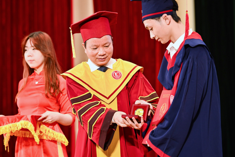 GS Vũ Văn Yêm trao kỷ niệm chương cho sinh viên tốt nghiệp xuất sắc. Ảnh: HUST