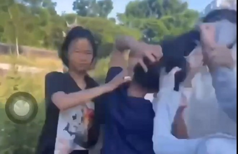 Nữ sinh (áo đen, thứ 2 từ trái sang) bị nhóm bạn túm tóc, liên tục đánh vào phần đầu. Ảnh cắt từ video/Lao Động