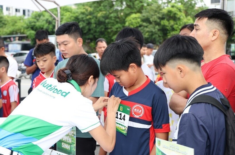 Các thí sinh nhí được gắn bib tại khu vực đăng ký tuyển sinh