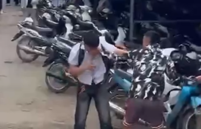Hình ảnh nam sinh lớp 12 bị những thanh niên lạ mặt xông vào trường hành hung. Ảnh: Người lao động