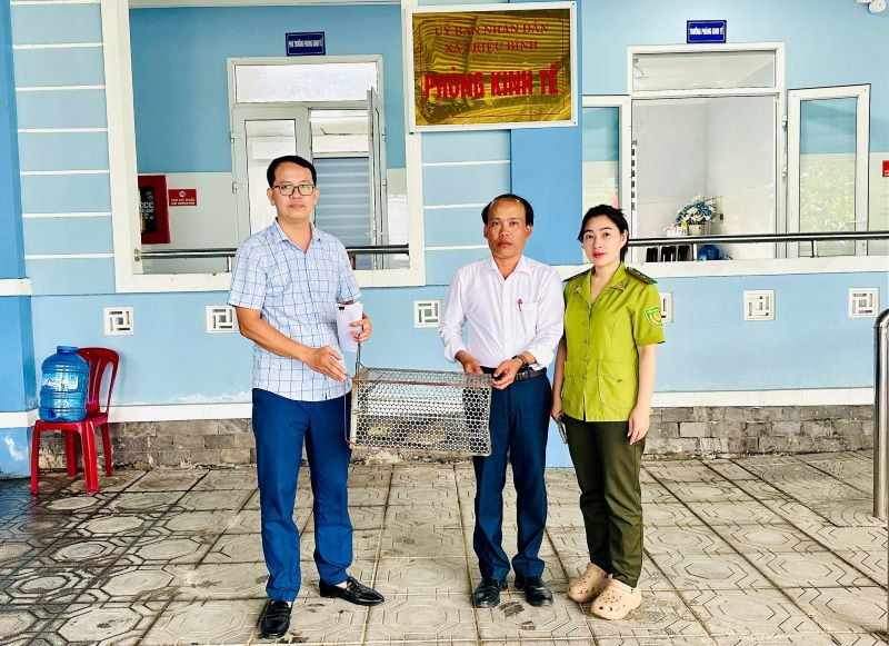 Người dân bàn giao cá thể kỳ đà vân.  Ảnh: Lao động