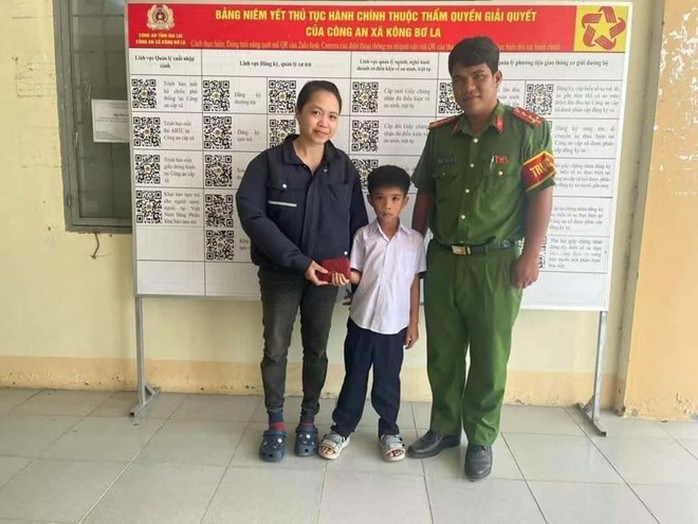 Em Khang (ở giữa) cùng Công an xã trao trả tài sản đánh rơi cho người dân. (Ảnh: Người lao động)