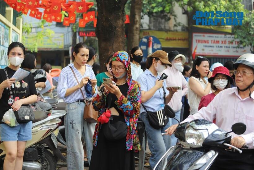 Dù trời oi nóng, các bậc phụ huynh vẫn chờ con bên phía ngoài điểm thi
