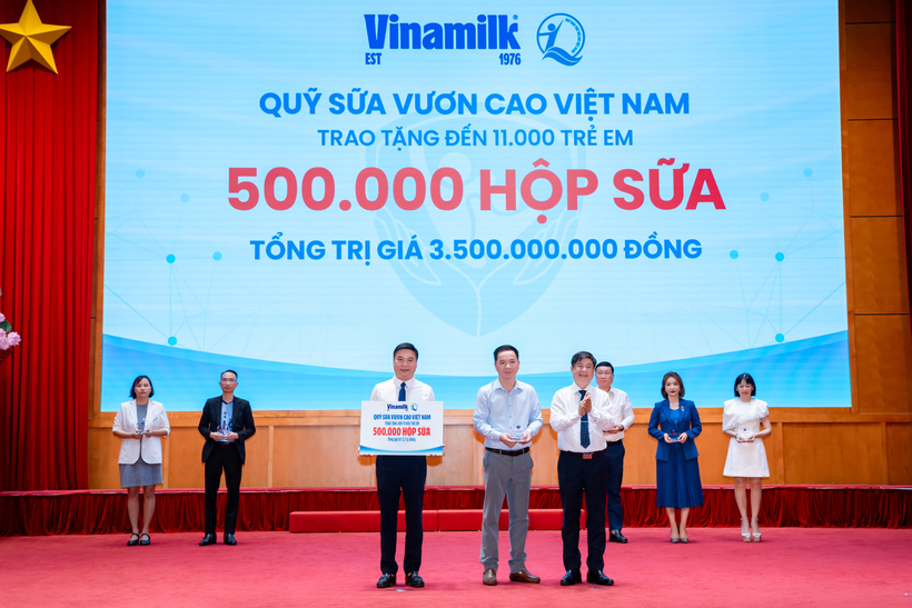 Đại diện Vinamilk (đứng giữa) trao bảng tượng trưng 500.000 hộp sữa và nhận kỷ niệm chương từ Bộ Y tế (Ảnh: VN).