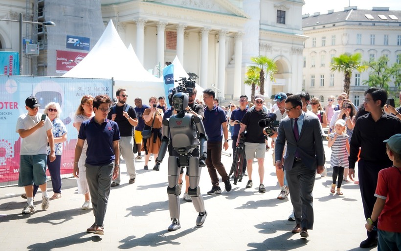 VR-H3 của VinRobotics thu hút sự chú ý với khả năng di chuyển tự nhiên tại Festival der Roboter 2026 ở Vienna, dưới sự chứng kiến của Đại sứ Việt Nam tại Áo, ông Vũ Lê Thái Hoàng (thứ hai từ phải sang, hàng trên), cùng đông đảo khách tham quan quốc tế. (Nguồn: VinRobotics)