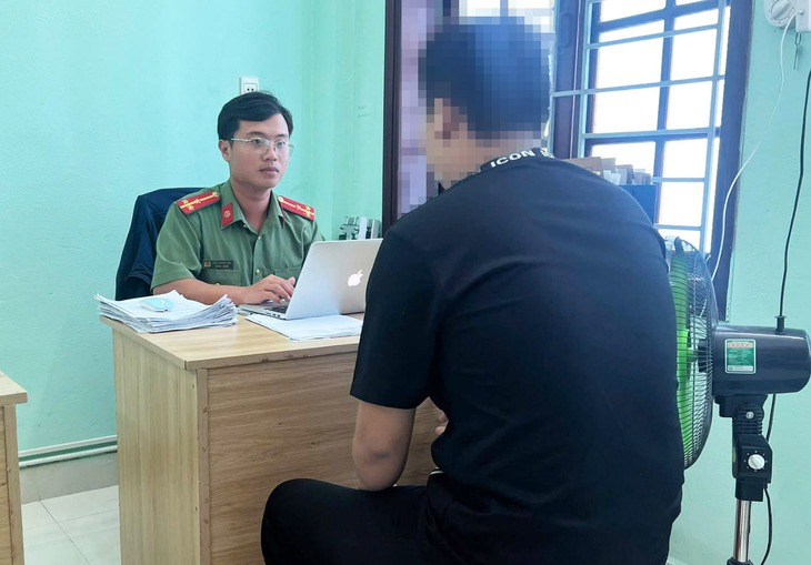 P.T.Đ. (áo đen) làm việc tại cơ quan công an (Ảnh: Công an xã Điện Bàn Tây).