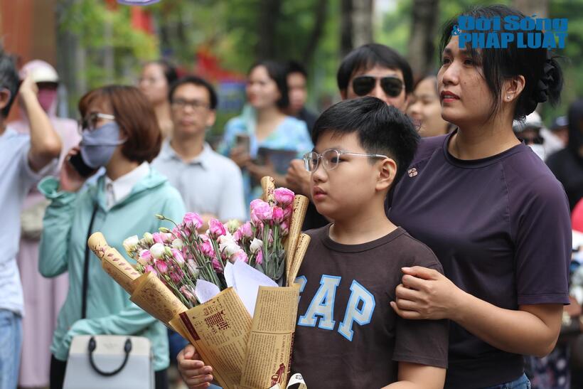Chị Quỳnh và con trai ôm bó hoa tươi chúc mừng con gái hoàn thành kỳ thi tốt nghiệp.